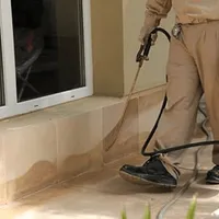 General pest control technician spraying exterior perimeter around a home in Myrtle Beach, SC