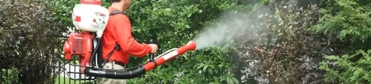 Mosquito control technician fogging shrubs and landscaping for mosquito treatment in Myrtle Beach, SC