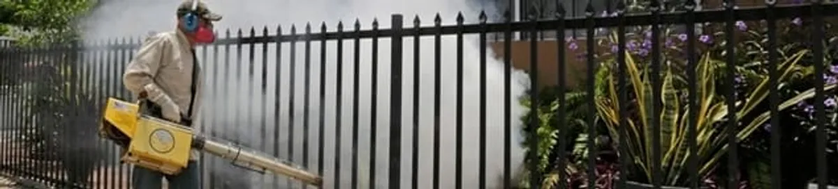 Mosquito control technician fogging a yard perimeter for mosquito reduction in Myrtle Beach, SC